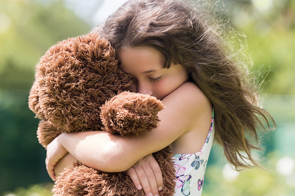 Girl hugs her Dori Teddy Bear