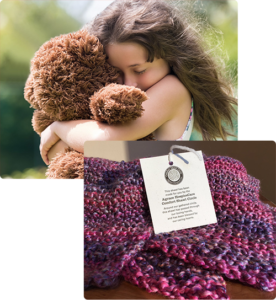 Girl cuddling Dori Bear & Comfort Shawl with tag