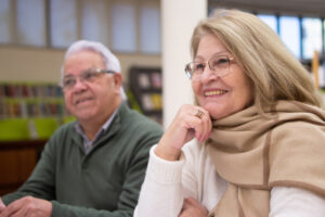 Portrait of happy elderly people attending study courses. Smiling man and woman listening to instructors teach about caring for people with dementia.